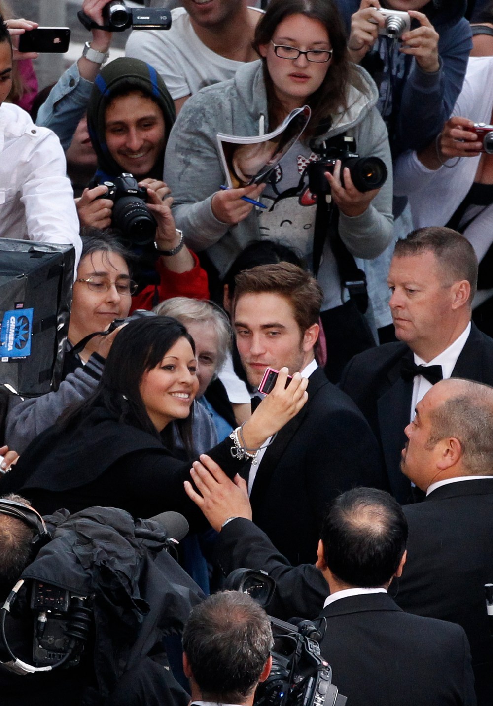 British actor Robert Pattinson (C) signs
